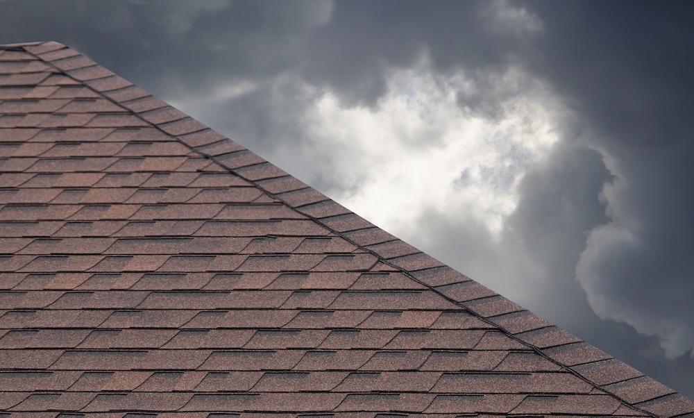 Home with brown roof shingles on cloudy day in rainy season.